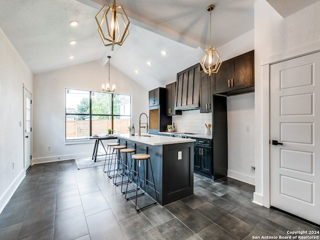 kitchen featuring pendant lighting, a breakfast bar, lofted ceiling with beams, an inviting chandelier, and a center island with sink