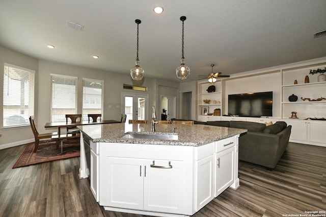 kitchen with dark hardwood / wood-style flooring, an island with sink, sink, and ceiling fan