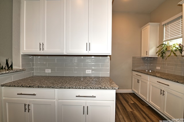 kitchen featuring dark stone counters, white cabinetry, decorative backsplash, and dark hardwood / wood-style floors