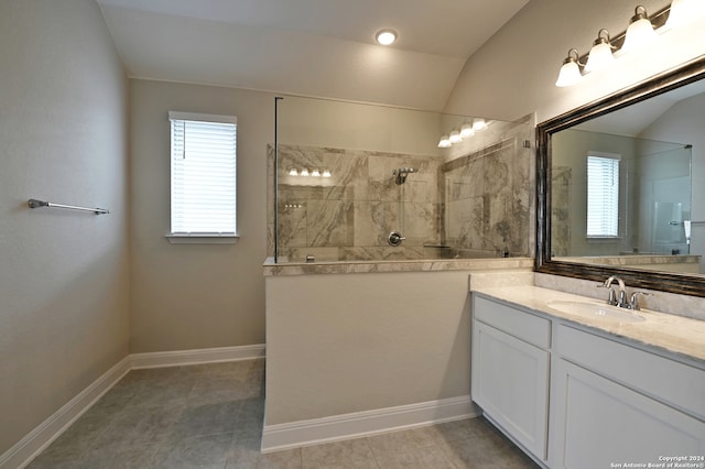 bathroom with lofted ceiling, tiled shower, tile patterned floors, and vanity