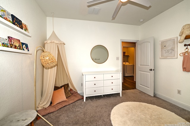 bedroom with washer / dryer, dark carpet, and ceiling fan