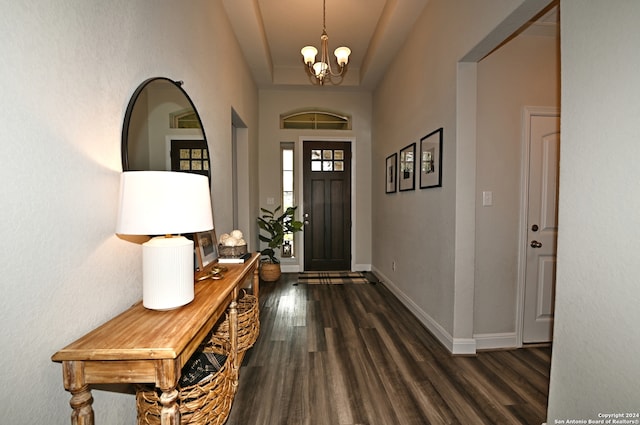 foyer entrance with dark wood-type flooring and a chandelier