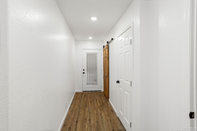 corridor featuring hardwood / wood-style floors and a barn door