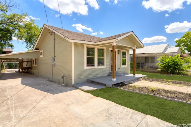 exterior space featuring driveway, a shingled roof, and a carport