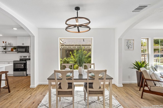 dining space featuring a notable chandelier and light hardwood / wood-style floors