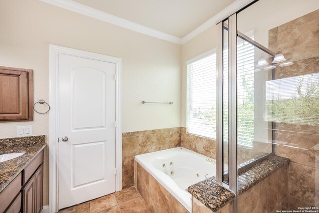 bathroom with plus walk in shower, tile patterned flooring, ornamental molding, and vanity