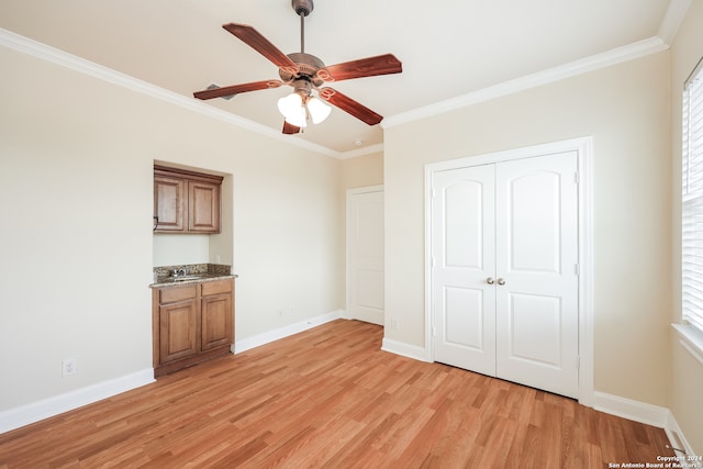 unfurnished bedroom with ornamental molding, multiple windows, and light wood-type flooring