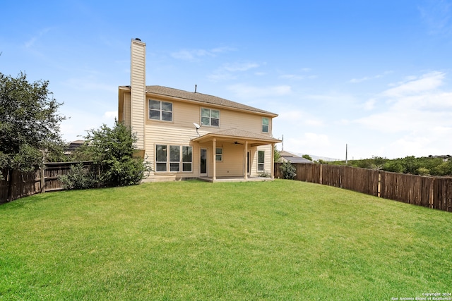 back of house with a yard and a patio