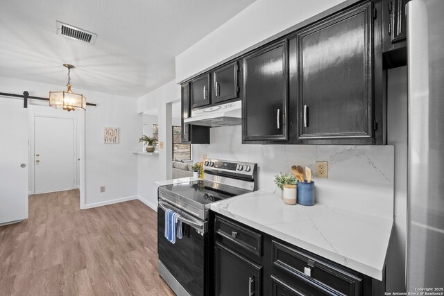 kitchen featuring pendant lighting, dark wood-type flooring, stainless steel appliances, sink, and a barn door