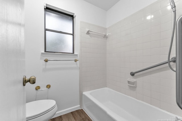 bathroom featuring tiled shower / bath, toilet, and hardwood / wood-style floors