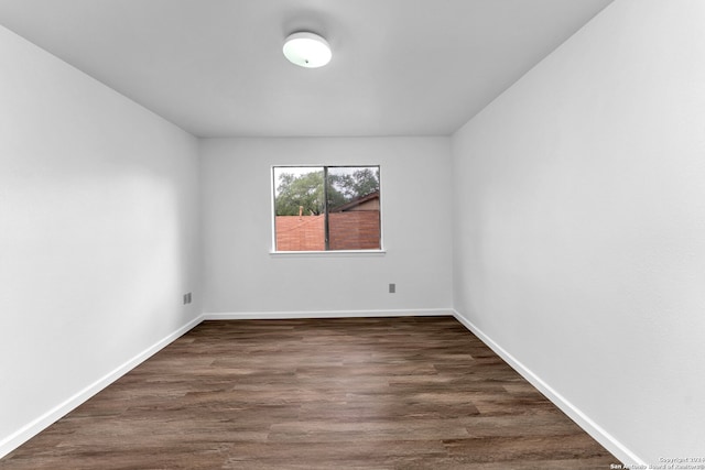 unfurnished room with dark wood-type flooring