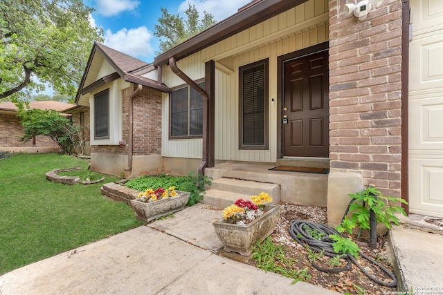 entrance to property featuring a porch and a lawn