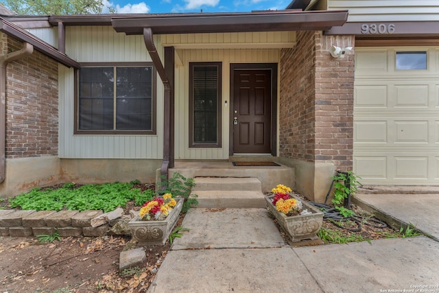 doorway to property featuring a porch and a garage