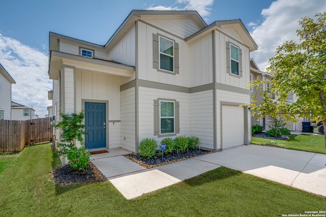 townhome / multi-family property featuring a garage and a front lawn