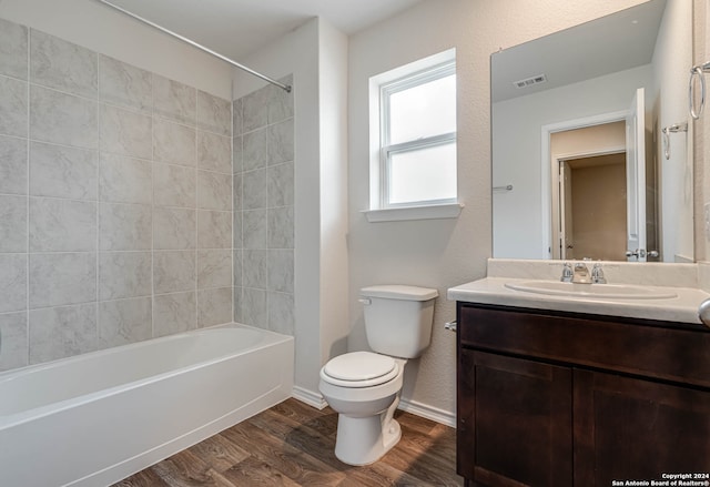 full bathroom featuring toilet, hardwood / wood-style flooring, tiled shower / bath, and vanity