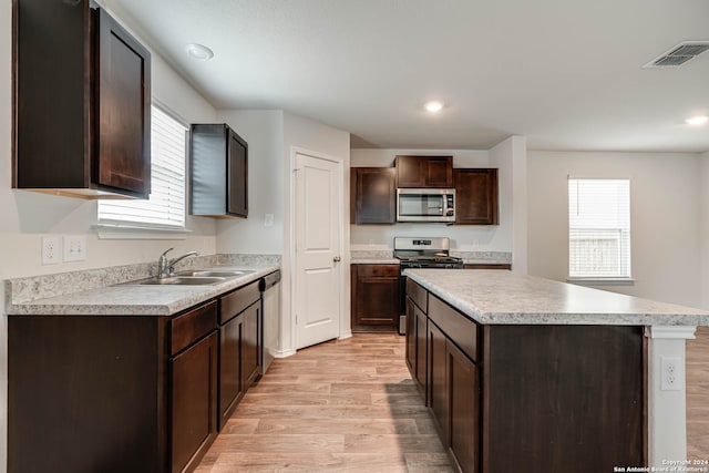 kitchen with light hardwood / wood-style flooring, stainless steel appliances, a center island, sink, and dark brown cabinetry