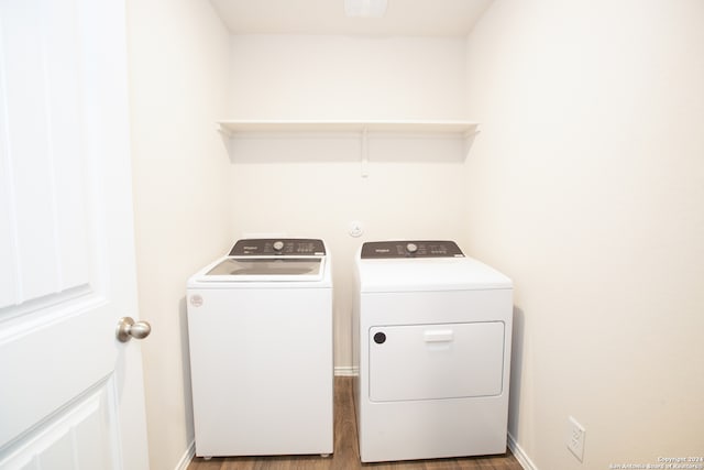 clothes washing area with wood-type flooring and washing machine and dryer