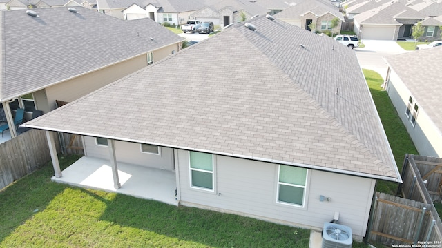 back of property with a yard, cooling unit, and a patio