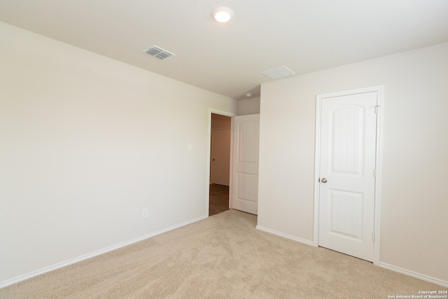 unfurnished bedroom featuring a closet and light carpet