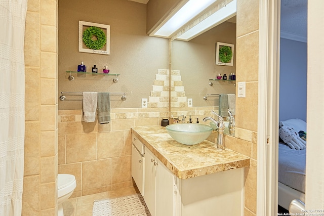 bathroom featuring tile patterned flooring, toilet, tile walls, decorative backsplash, and vanity