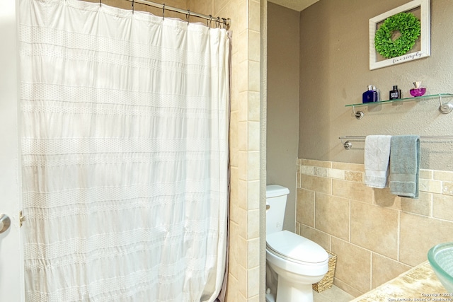 bathroom featuring tile walls, a shower with curtain, and toilet