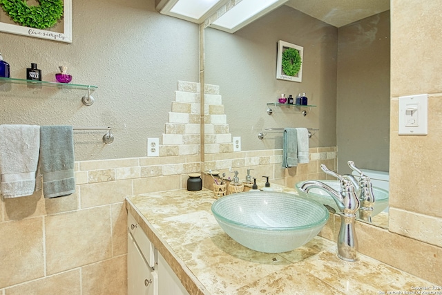 bathroom featuring vanity, tile walls, and backsplash