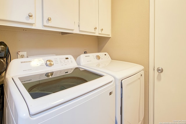 laundry area featuring cabinets and washer and clothes dryer