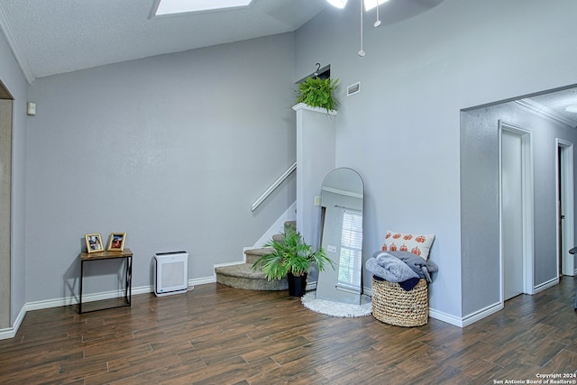 living room featuring vaulted ceiling with skylight, dark hardwood / wood-style floors, and ceiling fan