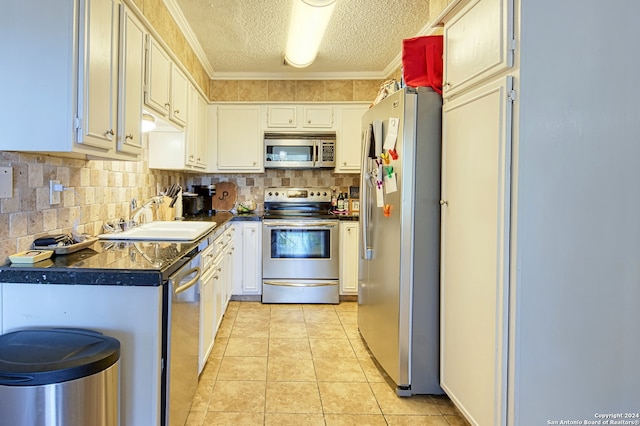 kitchen with ornamental molding, a textured ceiling, light tile patterned floors, sink, and appliances with stainless steel finishes