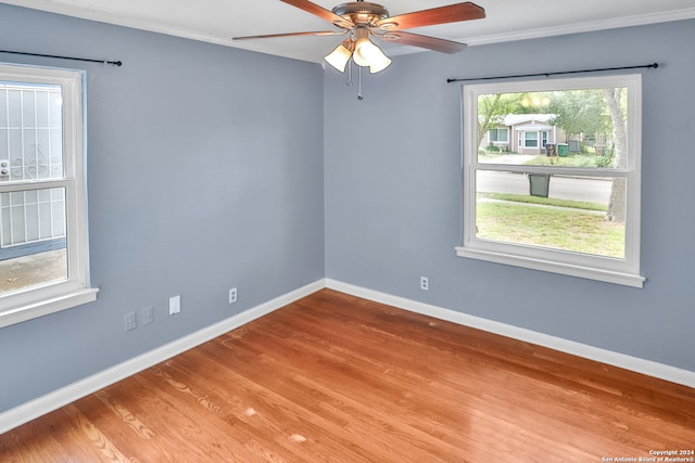 spare room featuring crown molding, hardwood / wood-style flooring, plenty of natural light, and ceiling fan