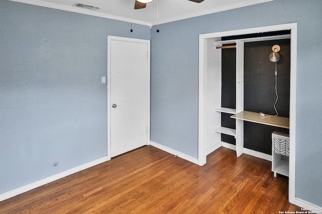 unfurnished bedroom featuring hardwood / wood-style floors, ceiling fan, a closet, and ornamental molding