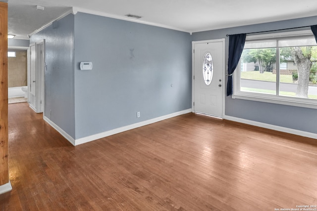 foyer entrance with crown molding and wood-type flooring