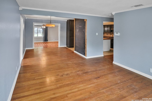 empty room featuring hardwood / wood-style flooring and ornamental molding