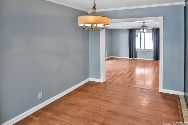 empty room with crown molding, hardwood / wood-style flooring, and ceiling fan