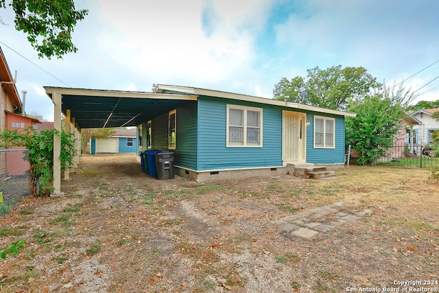 back of house featuring a carport