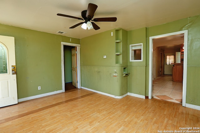 empty room with ceiling fan and light hardwood / wood-style floors