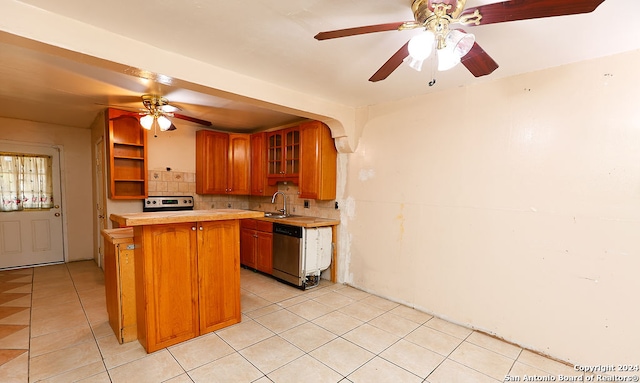 kitchen featuring kitchen peninsula, sink, ceiling fan, appliances with stainless steel finishes, and light tile patterned flooring