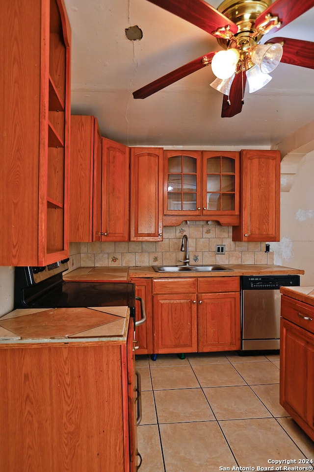 kitchen with sink, light tile patterned flooring, ceiling fan, tasteful backsplash, and stainless steel dishwasher