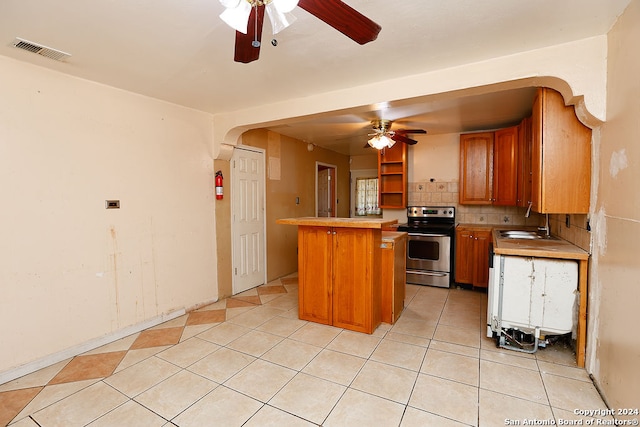 kitchen featuring stainless steel electric range, tasteful backsplash, sink, ceiling fan, and light tile patterned flooring