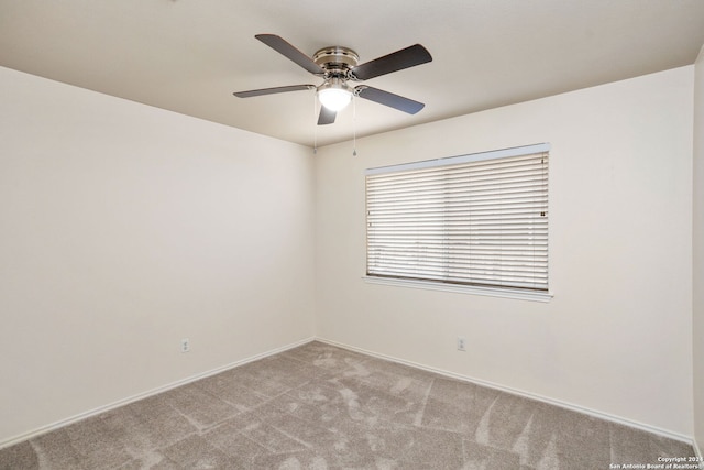 carpeted spare room featuring ceiling fan