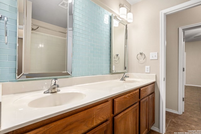 bathroom featuring tiled shower, tile patterned flooring, and vanity