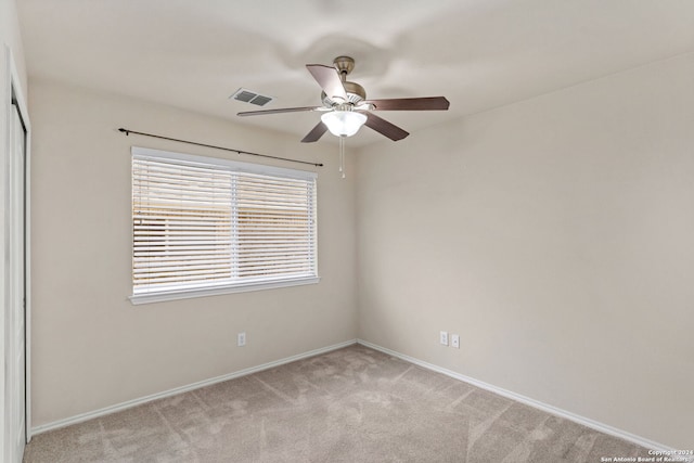 carpeted spare room with ceiling fan