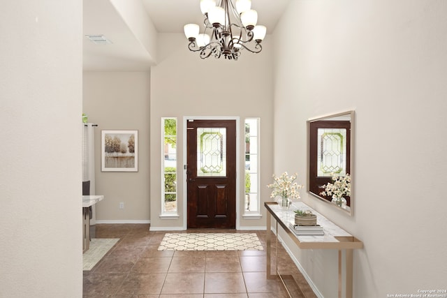 tiled foyer entrance with a towering ceiling and a notable chandelier