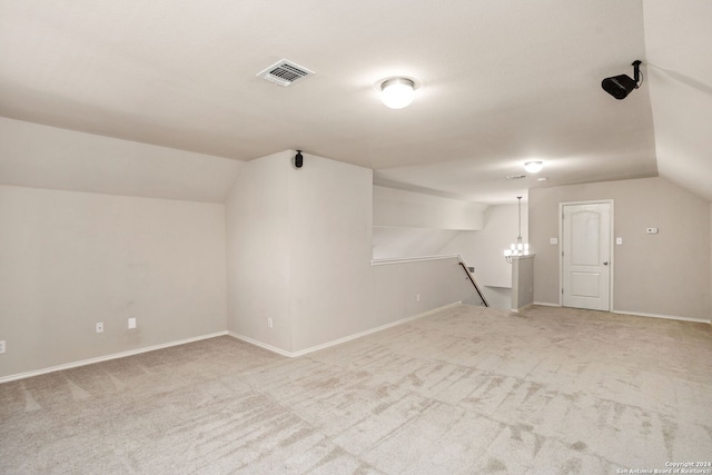 additional living space with light colored carpet and vaulted ceiling