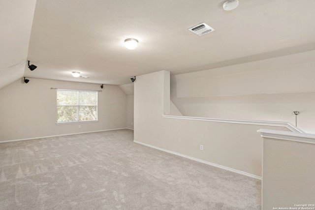 empty room featuring vaulted ceiling and carpet