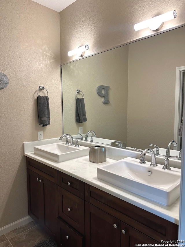 bathroom with tile patterned flooring, a textured ceiling, and vanity