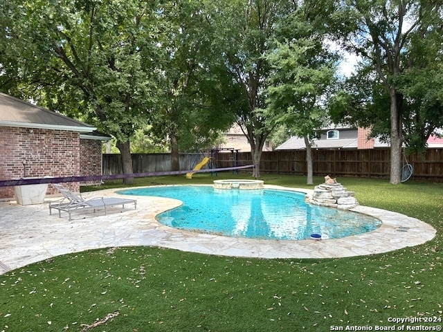 view of swimming pool with a lawn and a patio