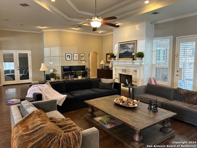 living room featuring ornamental molding, ceiling fan, dark hardwood / wood-style floors, and a tile fireplace