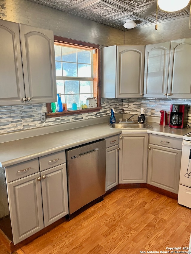 kitchen with dishwasher, tasteful backsplash, sink, white range with electric stovetop, and light wood-type flooring