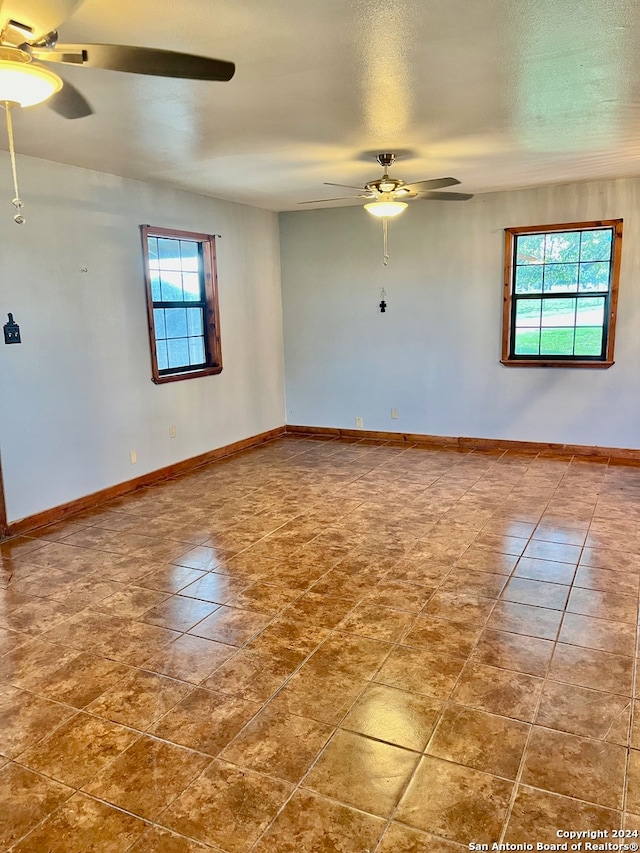 spare room with ceiling fan and a wealth of natural light